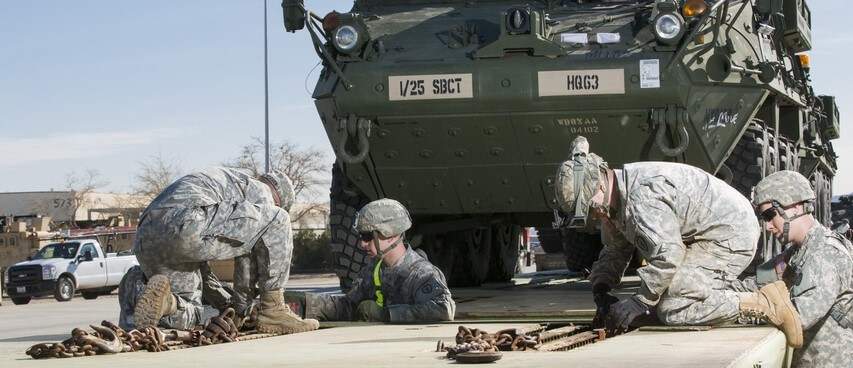 Soldiers secure an LAV to a trailer for transport